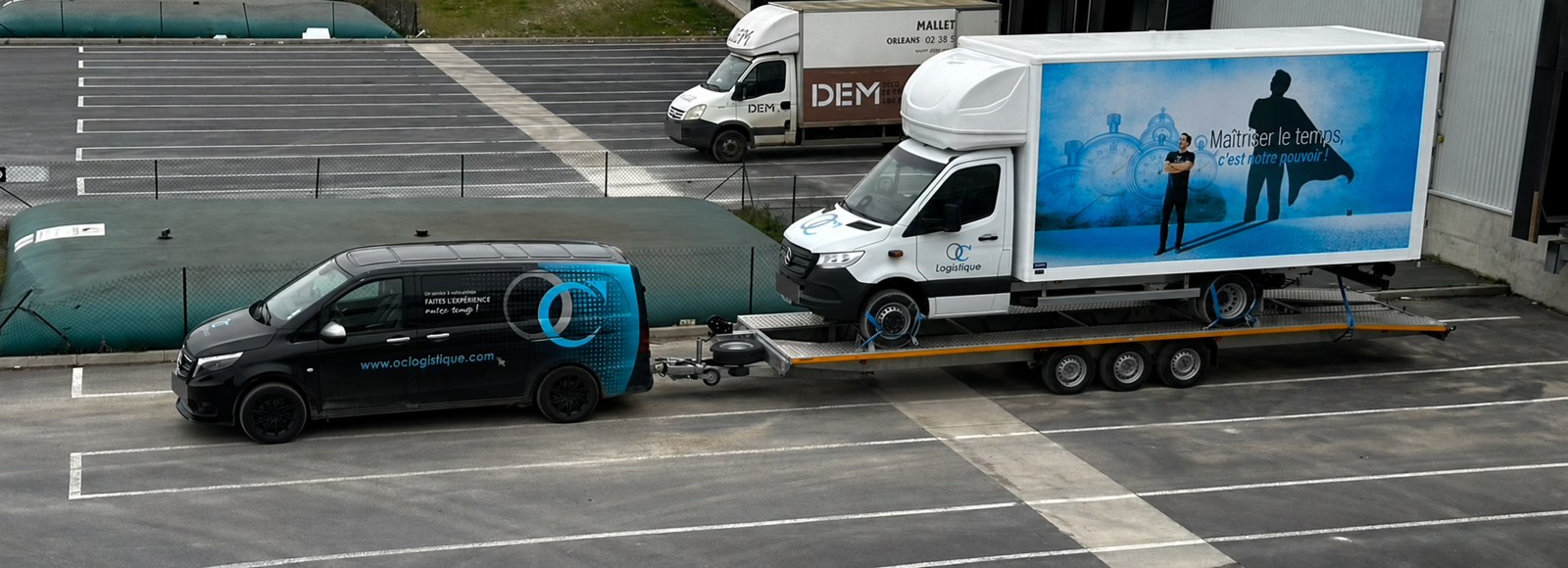 Véhicule OC LOGISTIQUE transporté sur une remorque plateau